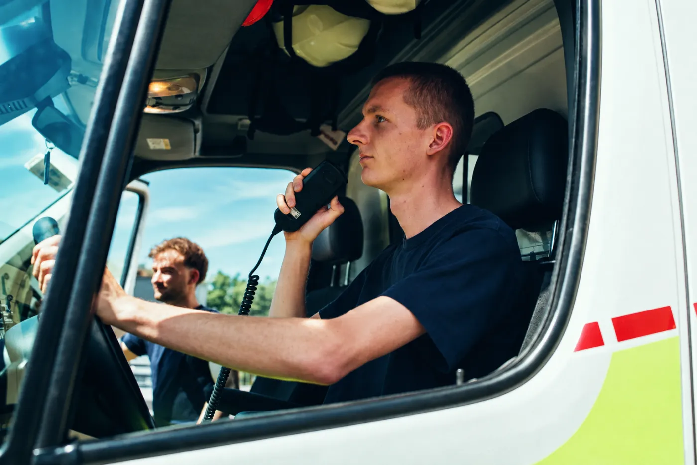 Rettungssanitäter am Steuer mit Funkgerät