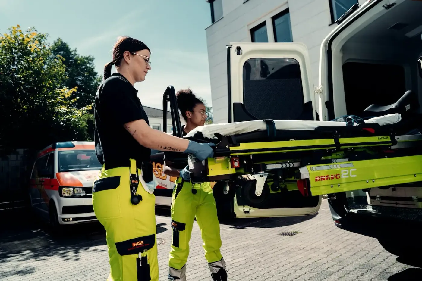 Team des Krankentransports mit einer Trage am Fahrzeug